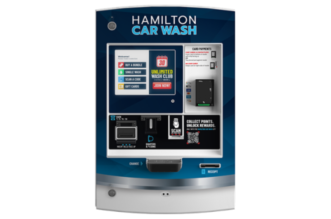 Hamilton <strong> Manufacturing </strong> A black SUV is being sprayed with blue water jets inside an automated car wash bay.