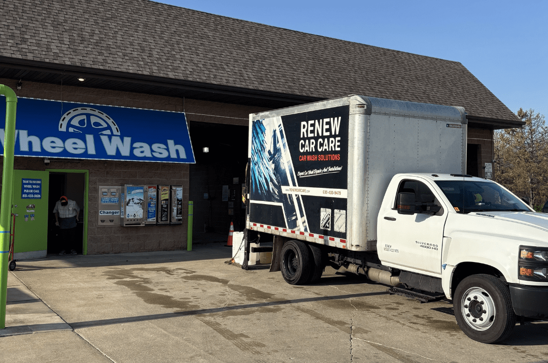 CarWashSoap.com <strong> Powered by </strong> ChemQuest A black SUV is being sprayed with blue water jets inside an automated car wash bay.