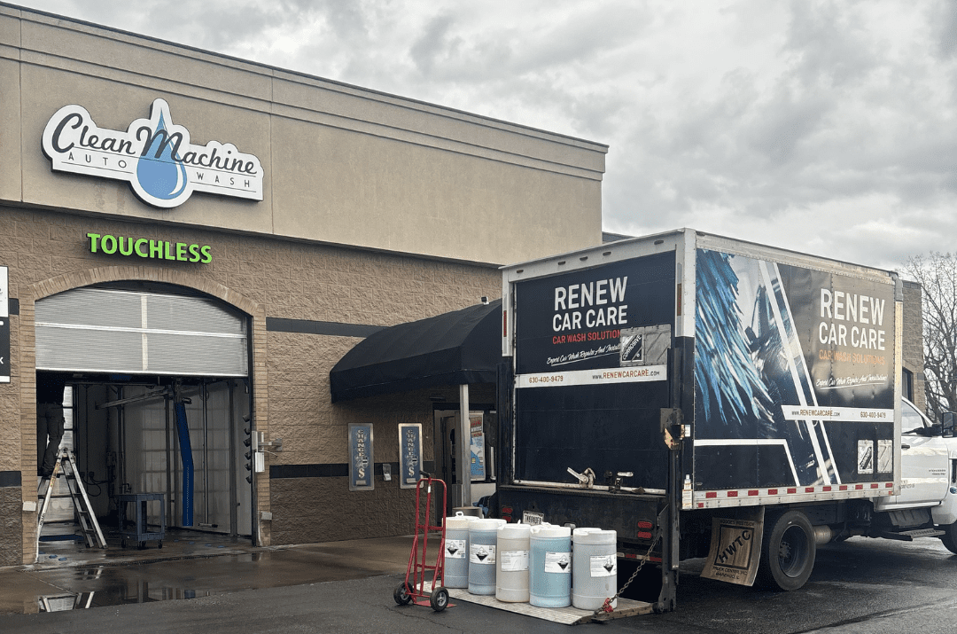 CarWashSoap.com <strong> Powered by </strong> ChemQuest A black SUV is being sprayed with blue water jets inside an automated car wash bay.