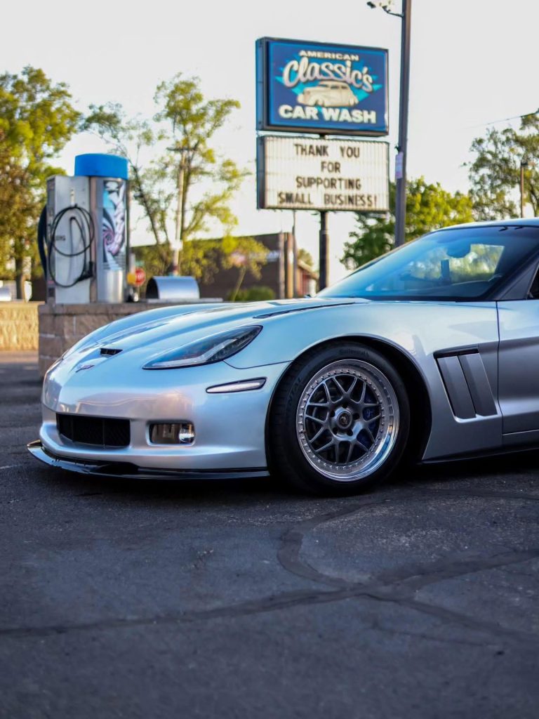 American Classic's Car Wash Finds Success with the Petit Accutrac®360-i A silver sports car parked in front of an old-fashioned car wash with a sign reading, "Thank you for supporting small business!.